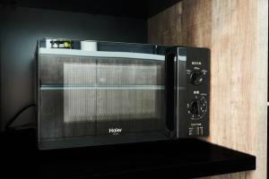 a microwave oven sitting on a shelf in a kitchen at Grand STAY 博多駅北 in Fukuoka