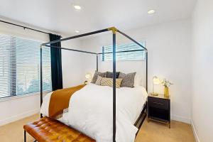 um quarto com uma cama de dossel e uma janela em Modern Peaks Townhome em Denver