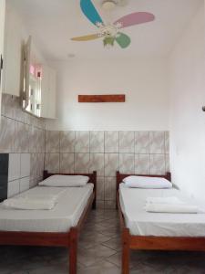 2 letti in una camera con ventilatore a soffitto di Chapadão Hostel a Lençóis