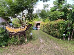 a garden with a statue of a bird on the side of a road at Koh Mook Bungalows in Ko Mook