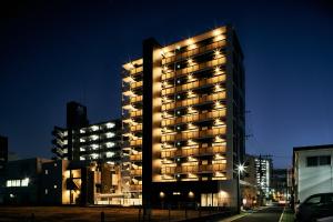 福岡市にあるGrand STAY 博多駅北の夜間照明付きの高層ビル