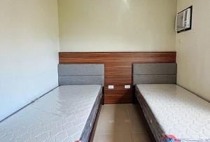 two beds in a small room with at RedDoorz @ Leoncia Apartelle Mandaue City in Mandaue City