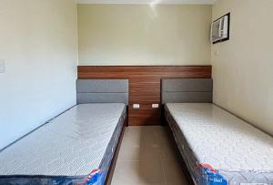 two beds in a small room with at RedDoorz @ Leoncia Apartelle Mandaue City in Mandaue City