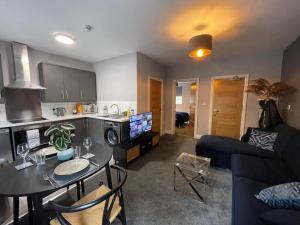 een keuken en een woonkamer met een tafel en een bank bij 5- Large 1 bed Apartment- West Midlands 