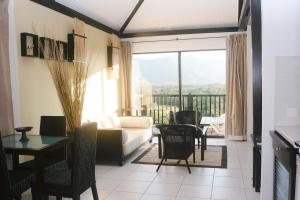 un soggiorno con divano, tavolo e sedie di Rivland Resort a Païta