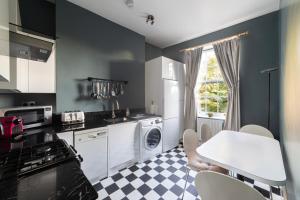 a kitchen with a table and a table and chairs at Ultra Central London, Modern Flat in Leafy Street in London