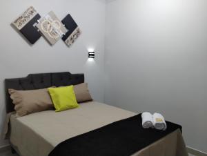 Un dormitorio con una cama con dos zapatos. en Hospedagem Encantos da Serra en Itatiaia