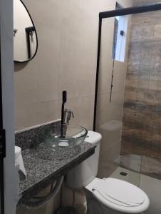 a bathroom with a sink and a toilet and a mirror at Hospedagem Encantos da Serra in Itatiaia