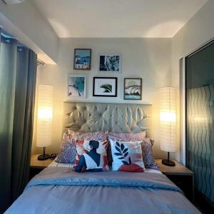 1 dormitorio con 1 cama grande con almohadas y 2 lámparas en Acqua Private Residence Livingstone Tower Condo Unit with Free Wifi, en Manila