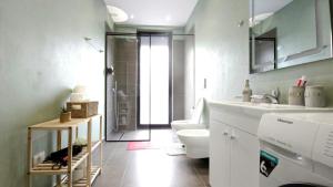 een badkamer met een toilet, een wastafel en een douche bij 999 Apartments in Tirana