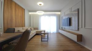 een woonkamer met een bank en een tafel met een televisie bij 999 Apartments in Tirana