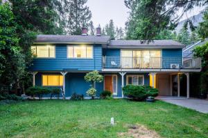 a blue house with a balcony and a yard at NorthVAN nature living home in North Vancouver