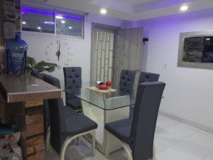 a dining room with a glass table and chairs at Karey 202,apartamento amoblado frente al mar in Rodadero