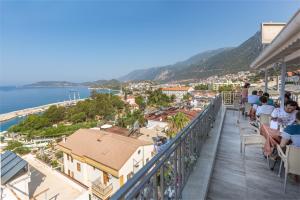 a balcony with a view of a city and the ocean at Defne Hotel in Kas