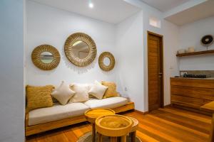 sala de estar con sofá y espejos en la pared en Villa Ryky 2-bedroom private luxury villa in Nyanyi Beach, en Tanah Lot