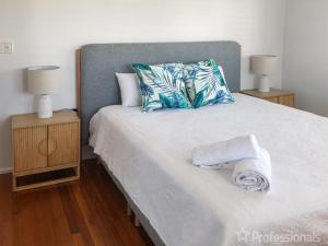 een slaapkamer met een bed met handdoeken erop bij Island Pines in Emu Park