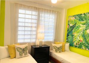 - une chambre avec 2 lits et une fenêtre avec des oreillers en papillon dans l'établissement Casa Lima in Villa Palmeras, à San Juan