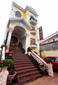 un edificio giallo con scale di fronte di Minh Cường Hotel a Mộc Châu