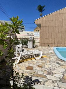 a pair of lounge chairs and a swimming pool at Pousada Volare in Matinhos