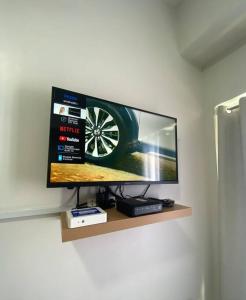 a flat screen tv sitting on a shelf on a wall at Eve's Condo in Cagayan de Oro