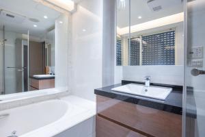 uma casa de banho com uma banheira, um lavatório e um espelho. em Comfy & Central 2B1b, Sleeps 5, 3min to Daan MRT 舒適市中心 2房1衛 睡5人 3分到大安站 em Taipei