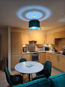 a kitchen with a table and chairs in a room at Waterfront, Ethihad stadium apartments in Manchester