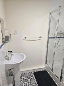 a white bathroom with a shower and a sink at Waterfront, Ethihad stadium apartments in Manchester