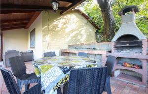 un patio con mesa, sillas y chimenea en Pet Friendly Home In Stella Cilento With House A Panoramic View, en Stella Cilento
