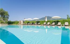 a large swimming pool with chairs and umbrellas at Pet Friendly Home In Stella Cilento With House A Panoramic View in Stella Cilento