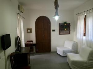 ein Wohnzimmer mit einem Stuhl und einer Tür in der Unterkunft B&B Le Sette Vele Da Riccardo in Santa Marina Salina