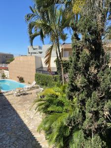 ein Resort mit einem Pool und einer Palme in der Unterkunft Pousada Volare in Matinhos