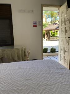 - une chambre avec un lit et une vue sur la cour dans l'établissement Pousada Volare, à Matinhos