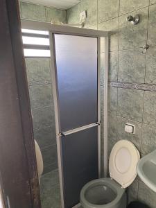 ein Bad mit einem WC und einer Hintertür mit einer Dusche in der Unterkunft Pousada Volare in Matinhos