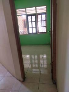 banyu urip kidul regency في سورابايا: غرفة فارغة بجدران خضراء ونافذة