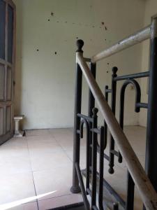 banyu urip kidul regency في سورابايا: حاجز درج في غرفة مع أرضية من البلاط