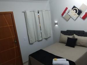 a small bedroom with a bed and a window at Hospedagem Encantos da Serra in Itatiaia