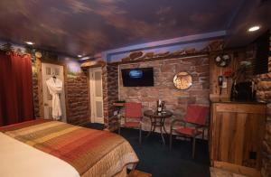 Cette chambre comprend un lit et un mur en pierre. dans l'établissement The Anniversary Inn - South Temple, à Salt Lake City