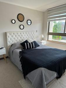 Un dormitorio con una cama grande y una ventana en Cómodo departamento 1D+1B, en Los Ángeles