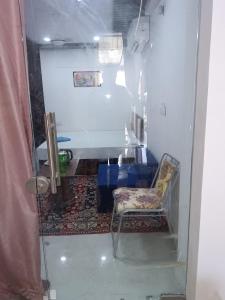 Zimmer mit einem Stuhl und einem Tisch sowie einem Zimmer mit einem Saud No B in der Unterkunft Hotel Balaji Residency in Udaipur