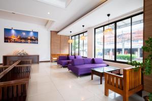 a waiting room with purple furniture and windows at The President Hotel at Chokchai 4 in Bangkok