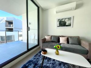 een woonkamer met een bank en een tafel bij Spacious cozy2BR close to OlympicPark free carpark in Sydney