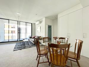 - un salon avec une table, des chaises et un canapé dans l'établissement Spacious cozy2BR close to OlympicPark free carpark, à Sydney