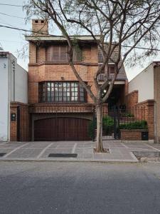 a brick house with a tree in front of it at Viajar y sentirse en casa! in Mendoza