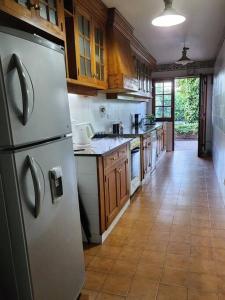 a kitchen with a stainless steel refrigerator and wooden cabinets at Viajar y sentirse en casa! in Mendoza