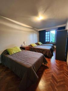 a bedroom with two beds and a window at Viajar y sentirse en casa! in Mendoza