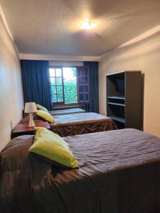 a hotel room with two beds and a window at Viajar y sentirse en casa! in Mendoza