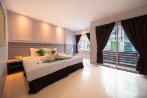 a bedroom with a large bed and a large window at FunDee Boutique Hotel in Patong Beach