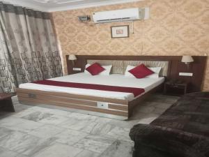 a bedroom with a large bed with red pillows at OYO 48765 Hotel Amandeep in Ludhiana