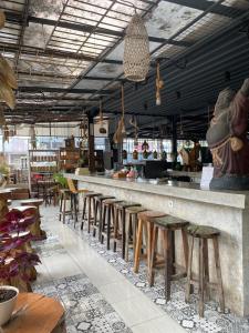 un restaurante con un bar largo con taburetes en The Reward Villas Kerobokan en Seminyak