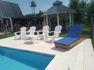 eine Gruppe Stühle und ein Pavillon neben einem Pool in der Unterkunft La Escapada San Pedro in San Pedro + 16 Fotos